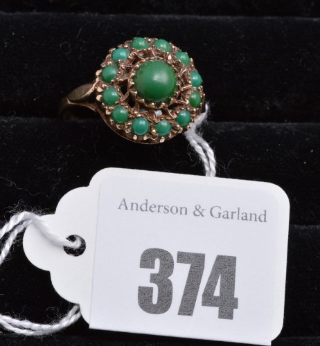 Lot 374 - A turquoise cluster ring on 9ct. yellow gold...