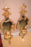 Lot 1185 - A pair of rococo style wall mirrors, eagle...