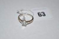 Lot 63 - A diamond ring, the oval facet cut diamond...