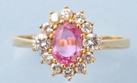 Lot 855 - A ruby and diamond cluster ring, the oval...