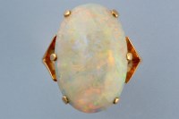 Lot 870 - An opal ring, the oval opal cabouchon in six...