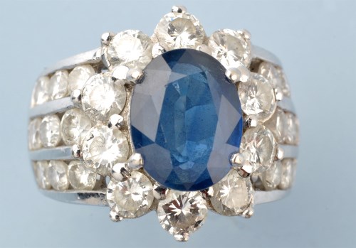 Lot 911 - A sapphire and diamond ring, the oval facet...