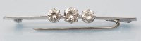 Lot 932 - A three stone diamond bar brooch, the...