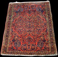 Lot 955 - A Sarouk rug, with floral scrolls on red...