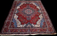 Lot 956 - A Heriz carpet, red ground decorated with...