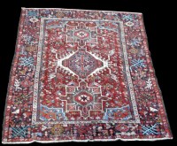 Lot 1007 - A Heriz rug, with triple medallion, on red...