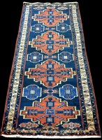 Lot 1030 - A Hamadan runner, with red medallions on blue...