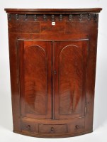 Lot 1144 - A George III mahogany bowfront hanging corner...