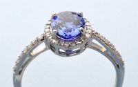 Lot 710 - A tanzanite and diamond cluster ring, the oval...