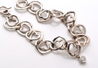 Lot 722 - A white metal heart pattern bracelet, the...