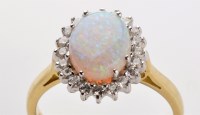 Lot 727 - An opal and diamond cluster ring, the oval...