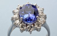 Lot 767 - A tanzanite and diamond cluster ring, the oval...