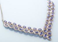 Lot 798 - A tanzanite necklace, set with thirty-six oval...