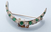 Lot 825 - A diamond and emerald crescent pattern brooch,...