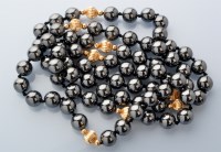 Lot 833 - A hematite and 14ct. yellow gold bead necklace,...