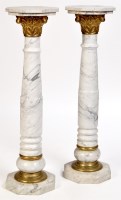 Lot 1200 - A pair of grey veined white marble pedestals,...