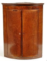 Lot 1326 - A George III oak bowfront hanging corner...