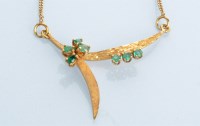 Lot 964 - An emerald and 18ct yellow gold necklace, the...