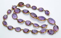 Lot 979 - An amethyst necklace, set with twenty-six oval...