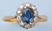 Lot 980 - A sapphire and diamond cluster ring, the oval...