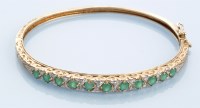 Lot 1010 - An emerald and diamond bangle, the eleven...