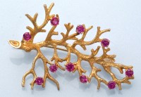 Lot 1034 - A ruby set yellow metal branch pattern brooch,...