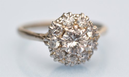Lot 1039 - A diamond cluster ring, the central brilliant...
