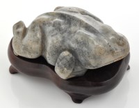 Lot 594 - Speckled grey jade toad, with lowered head and...