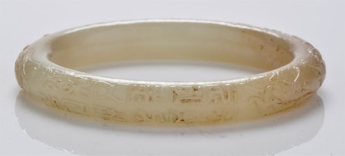 Lot 596 - Variegated celadon jade bangle, the edge with...