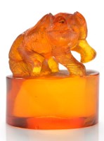 Lot 636 - Amber 'beast' seal, in a crouched position...