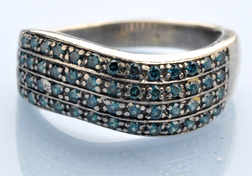 Lot 1225 - A blue diamond ring, set in four rows of wave...