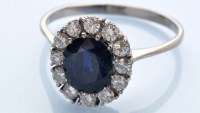 Lot 1238 - A sapphire and diamond cluster ring, the oval...