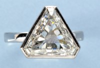 Lot 1264 - A triangular step-cut diamond ring, estimated...