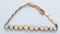 Lot 1272 - An opal and yellow metal bracelet, the eleven...