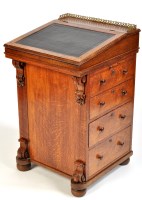 Lot 1430 - *A Victorian oak Davenport, the sliding top...