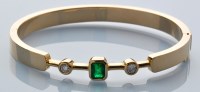 Lot 632 - An emerald, diamond and yellow metal bangle,...