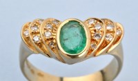 Lot 657 - An emerald and diamond ring, the oval facet...