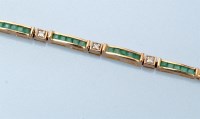 Lot 664 - An emerald, diamond and 9ct. yellow gold...