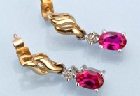 Lot 669 - A pair of ruby and diamond drop earrings, the...