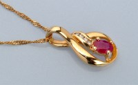 Lot 670 - A ruby and diamond pendant, the oval facet cut...