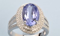 Lot 690 - A tanzanite and diamond cluster ring, the oval...