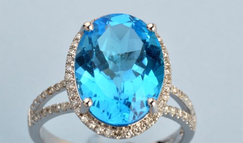 Lot 691 - A topaz and diamond cluster ring, the oval...