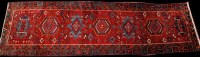 Lot 886 - A Heriz runner, the red field decorated with...