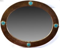 Lot 1071 - An Arts & Crafts oval wall mirror, the...