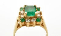 Lot 714 - An emerald and diamond cluster ring, the...