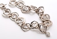 Lot 769 - A white metal heart pattern bracelet, the...