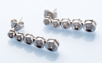 Lot 784 - A pair of diamond drop earrings, the graduated...