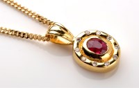 Lot 788 - A ruby and diamond cluster pendant, the oval...