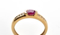 Lot 792 - A ruby and diamond ring, the oval facet cut...