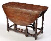 Lot 1209 - An early 18th Century oak drop leaf table, the...